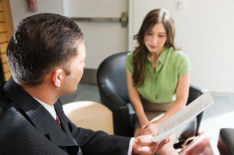 The photo shows a job interview with a recruiter and a job applicant discussing job interview questions