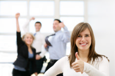 photo shows a group of people jumping in the air and giving a thumbs up celebrating success